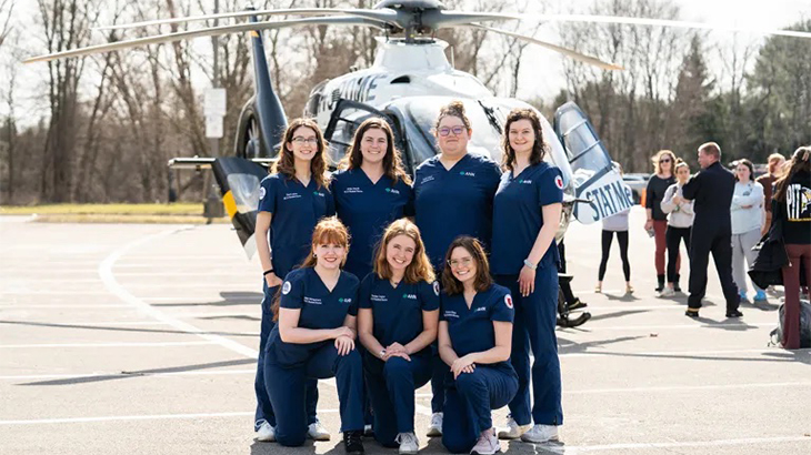 Grove City/BC3 R/N Graduates stand in front of a medevac helicopter. 
