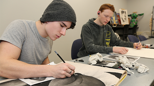 Art students working on charcoal drawings