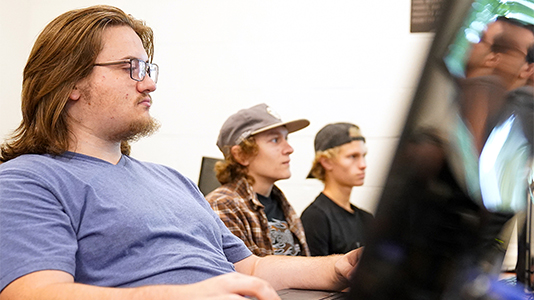 Image: BC3 students in a computer lab classroom working on desktop computers