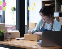 person writing shipping labels for their small business products