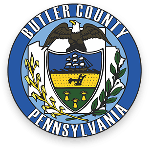 Image: Butler County Pennsylvania Seal with blue ring on the outside, a bald eagle illustration at the top, and a seal in the middle outlined by an olive branch and a wheat branch on either side