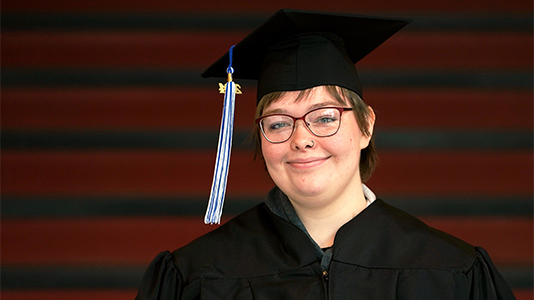 Image: a photo of a female graduate with a black cap and gown