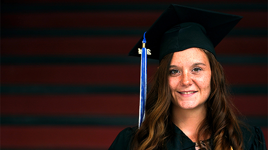 Image: photo of a female graduate wit a black cap and gown