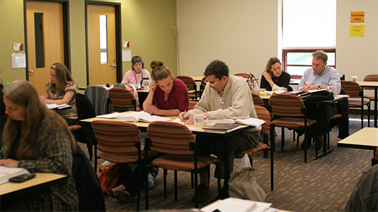 Students sitting at tables with tutors in the Academic Center for Enrichment in the SSC on BC3's Main Campus.